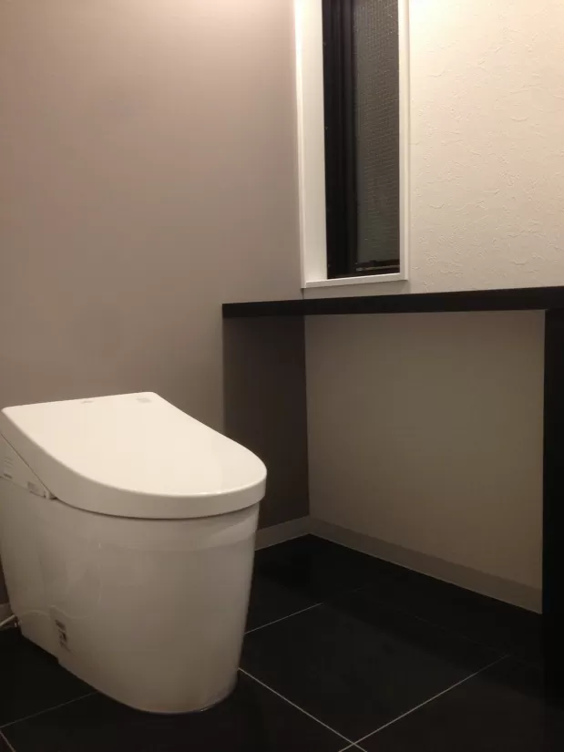 トイレのアクセントウォールにライトグレーの壁紙クロスを使用した実例