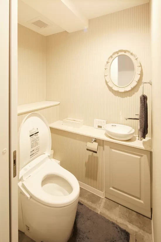トイレのアクセントウォールにストライプ柄の壁紙クロスを使用した実例