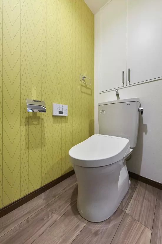トイレのアクセントウォールにイエローの壁紙クロスを使用した実例